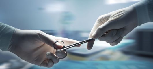 surgeons hands holding surgical scissors